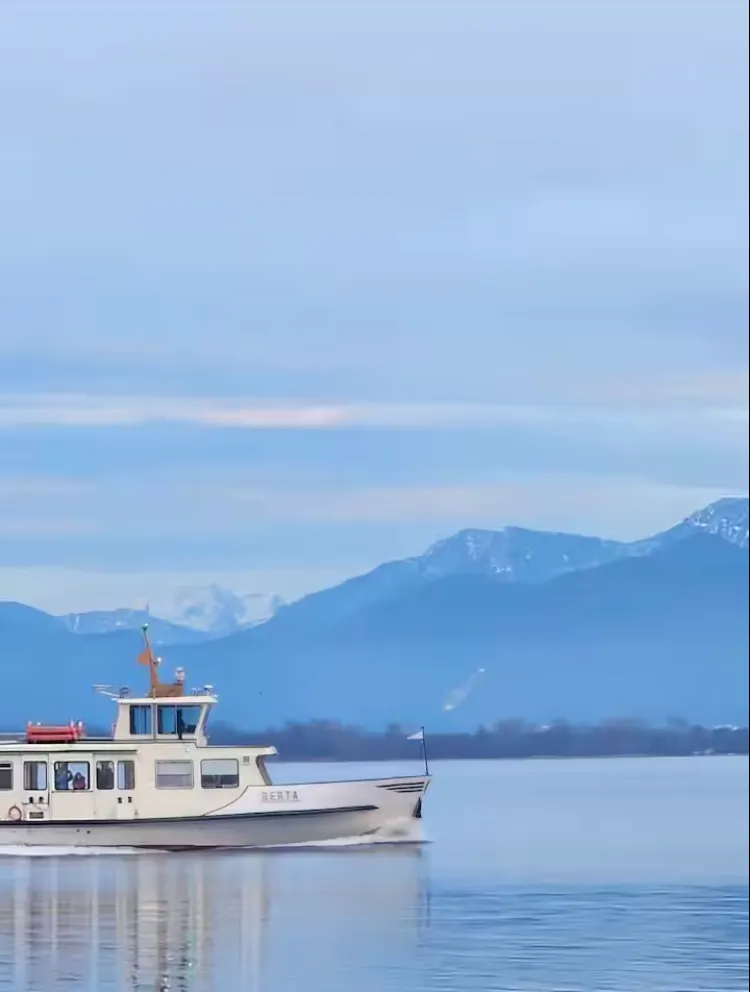 Ausflugsschiff der Chiemsee-Schifffahrt vor verschneiten Bergen