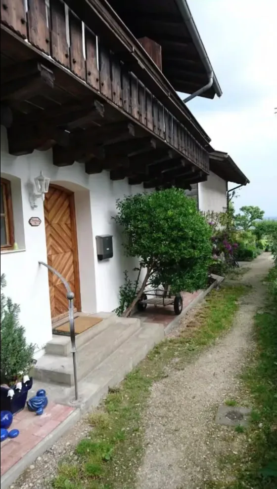 Fassade des Hauses am See mit Blumen und Holzbalkon