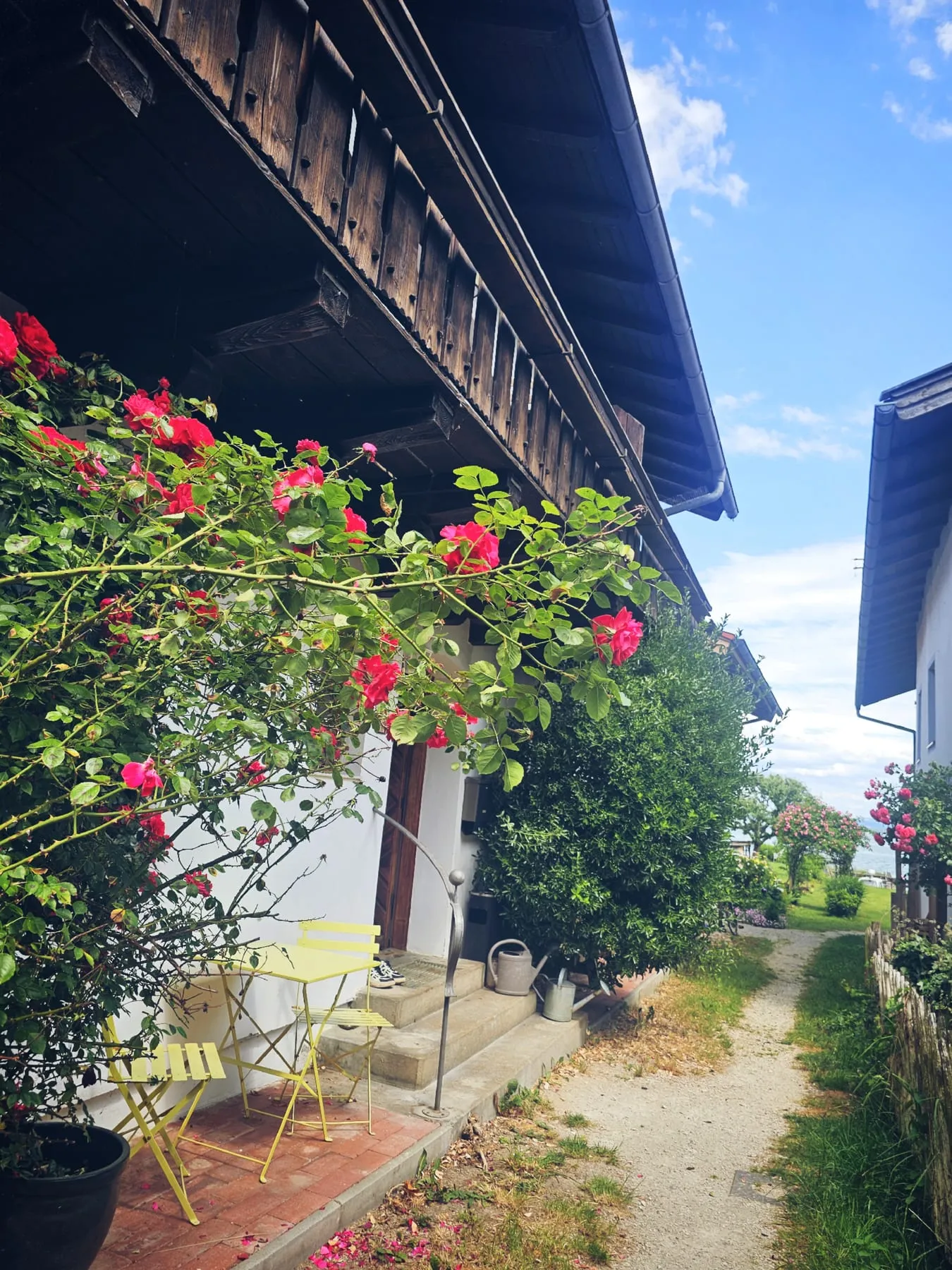 Fassade des Hauses am See mit Blumen und Holzbalkon